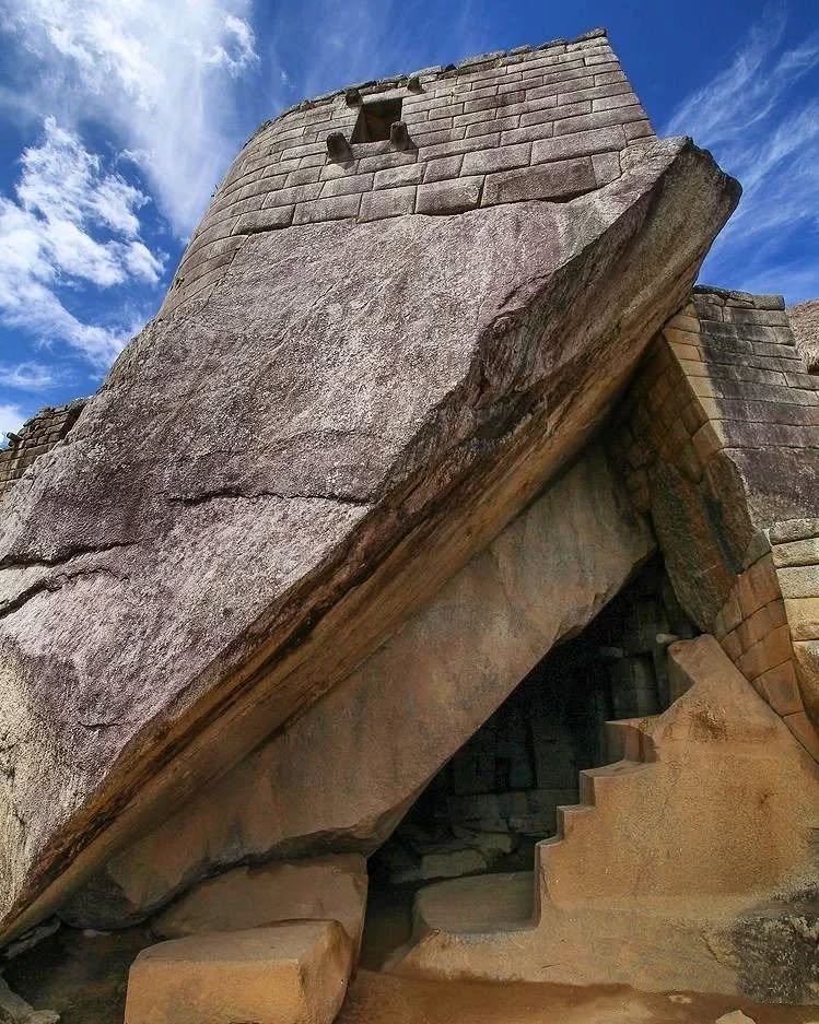 View of the Temple of the Sun at the top of the structure and below, the cave known as, The Royal Tomb in Machu Picchu.